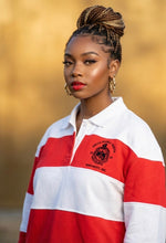Load image into Gallery viewer, Woman wearing a red and white striped shirt with a logo against a blurred background