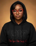 Person wearing a black hoodie with text on a brown background